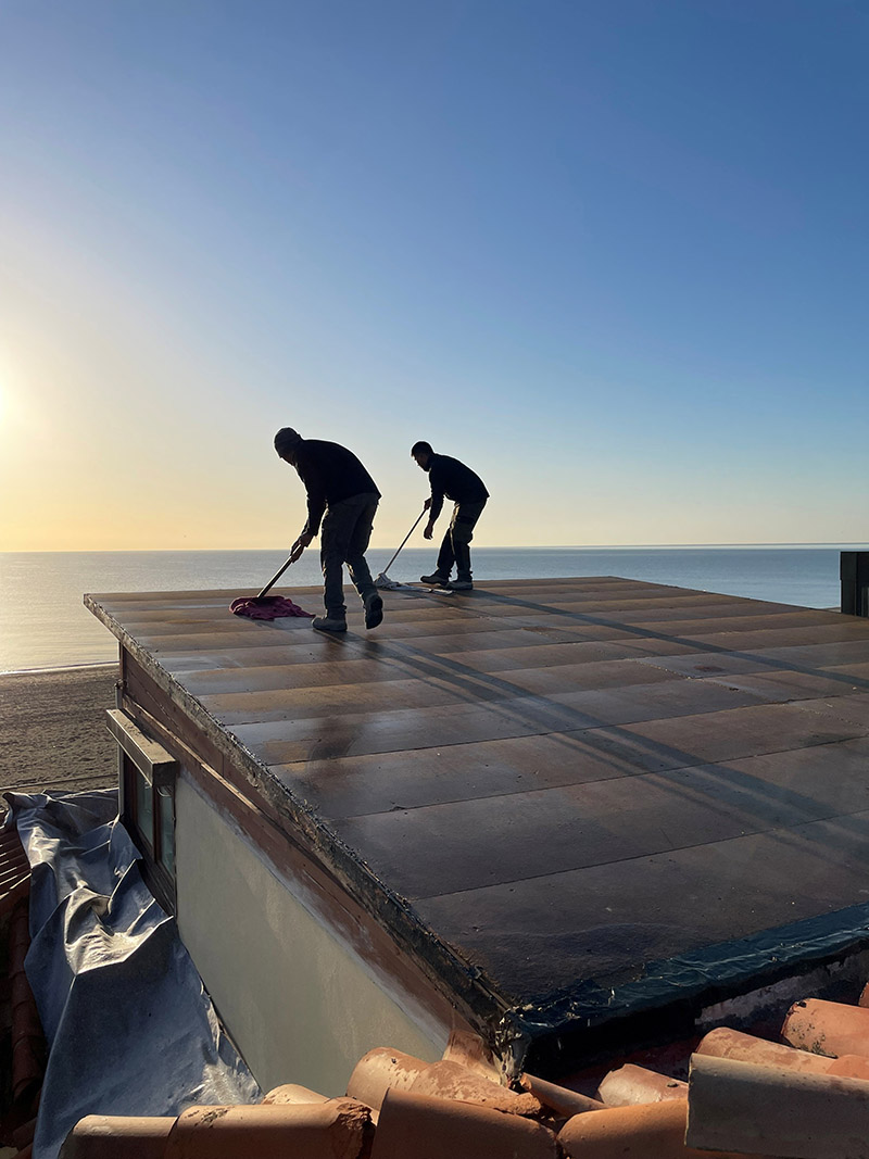 cleaning flat roof roofers on a flat roof in marbella cleaning it